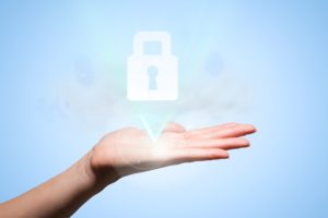 composite of hand holding padlock graphic over blue
