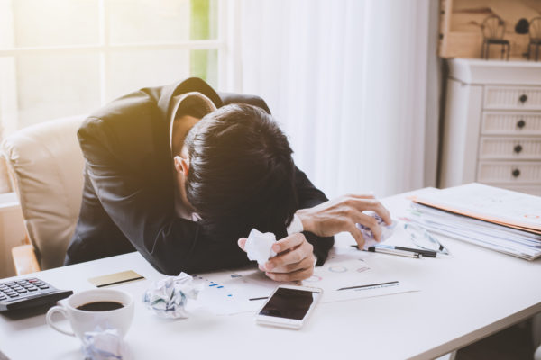 Businessman feeling sick and tired of debt